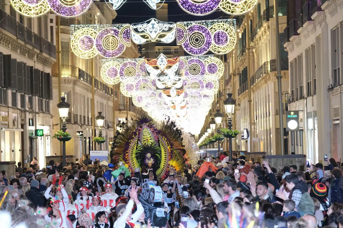 Menschenmengen feiern den Karneval von Malaga in der beleuchteten Calle Larios