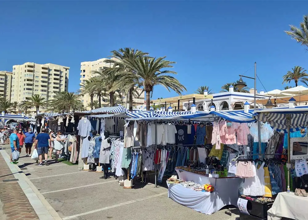 Kledingkraampjes op de straatmarkt van de haven van Estepona