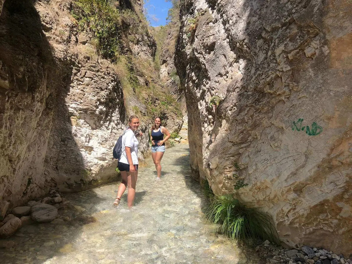 Randonneurs passant entre les rochers qui font partie du sentier du Rio Chillar