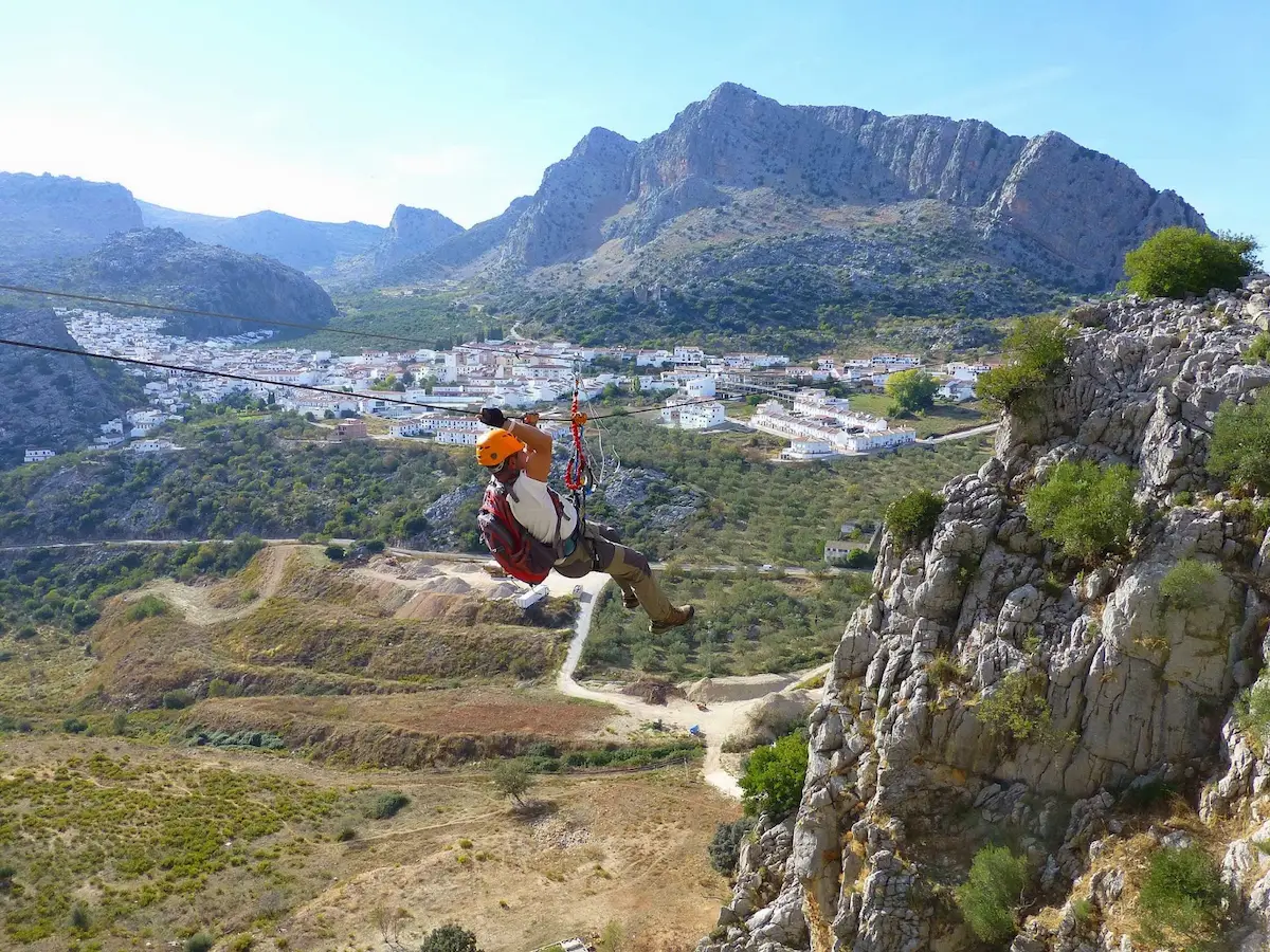 Man on the thrilling zip line of the Via Ferrata in Montejaque