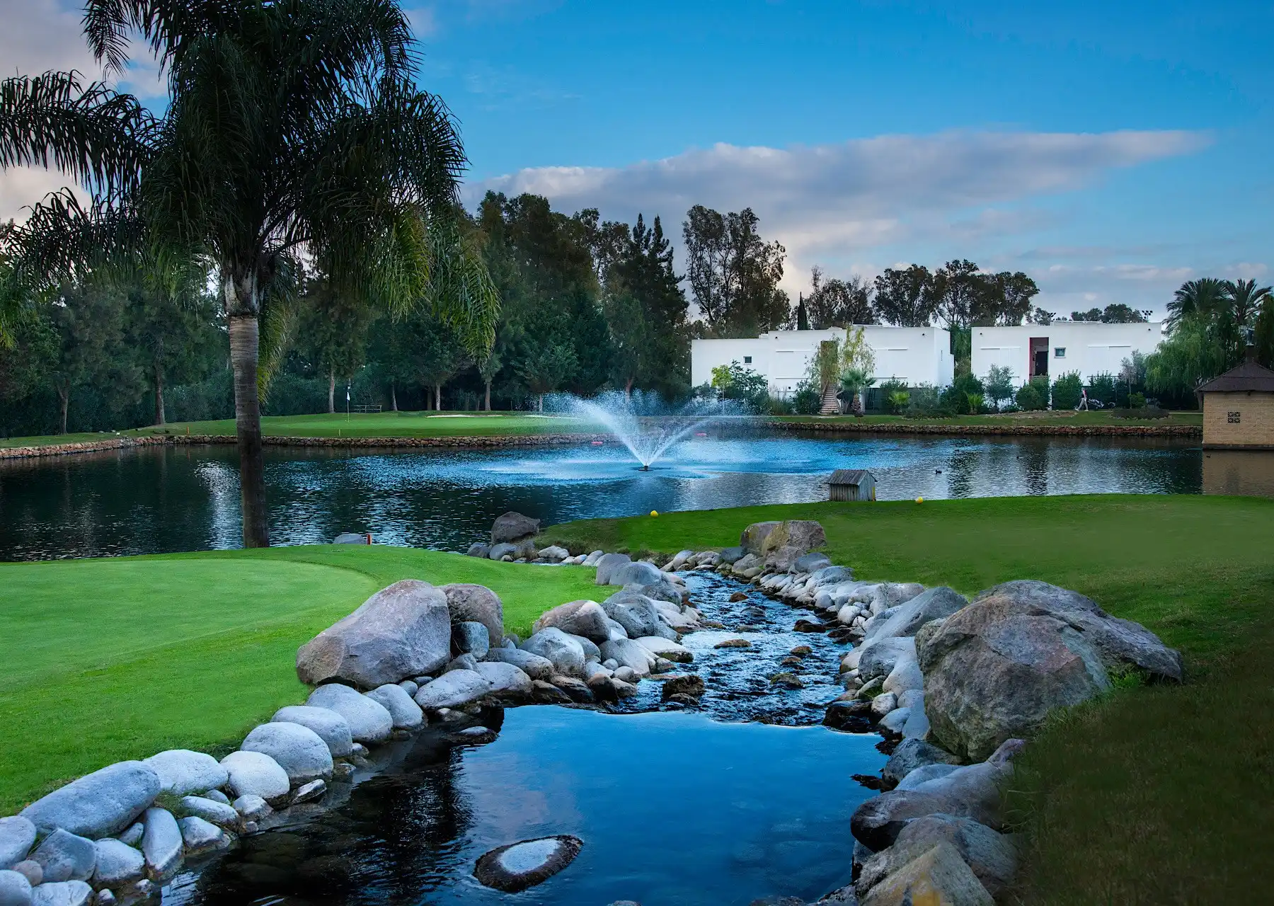 Uitzicht op een vijver en meer bij de golfbaan La Noria