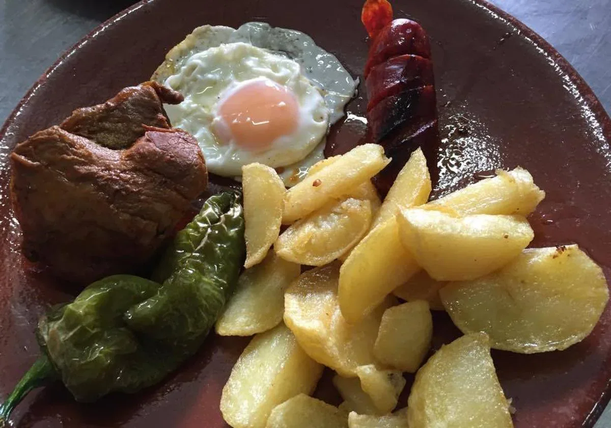 Piatto di montagna, lombo di maiale in lardo, patate, uova, chorizo e pepe